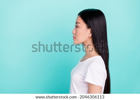 Profile side photo of young attractive asian girl look empty space concentrated isolated over turquoise color background