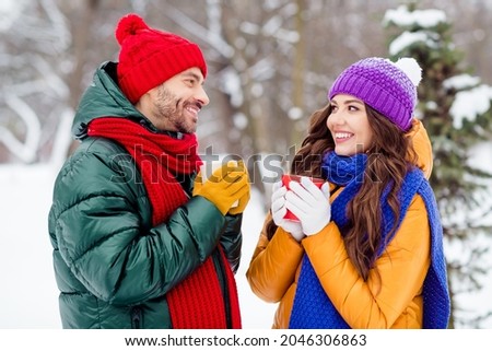Photo of adorable sweet girlfriend boyfriend dressed vests smiling talking drinking hot tea walking snow outdoors forest