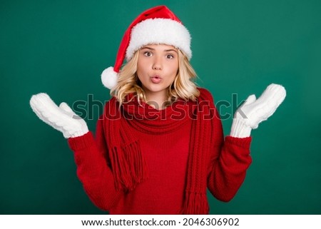 Photo of young girl pouted lips amazed shocked hands mittens shrug shoulders isolated over green color background