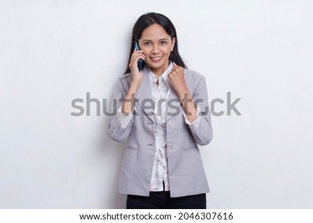 happy young asian business woman using mobile phone isolated on white background
