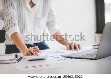 business woman or accountant who are using a calculator to calculate business data Accounting documents and laptop computer at the office business idea