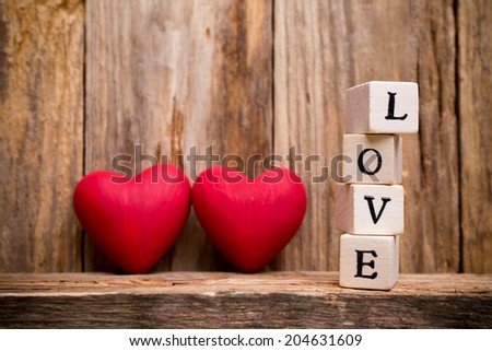Written on wooden blocks love and red heart.