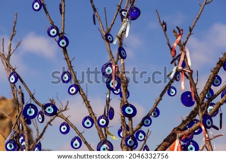 Blue evil eye ;nazar boncugu, turkish symbols hanging on a tree. cappadocia
