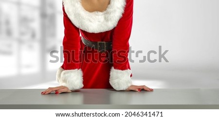 Slim younf woman in red dress and gray desk of free space for your decoration. 