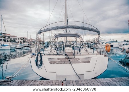White sailing yacht on the quay in the port on a cloudy day, view from the stern. High-quality photo Royalty-Free Stock Photo #2046360998