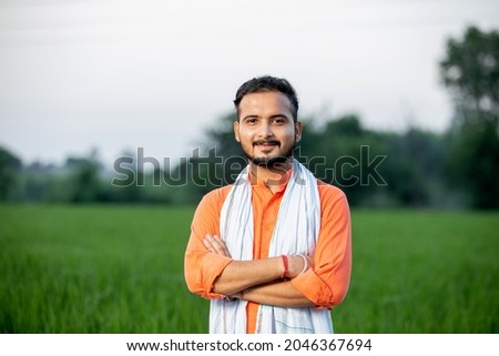 center positioned portrait of young indian farmer in farm field background rural india Royalty-Free Stock Photo #2046367694