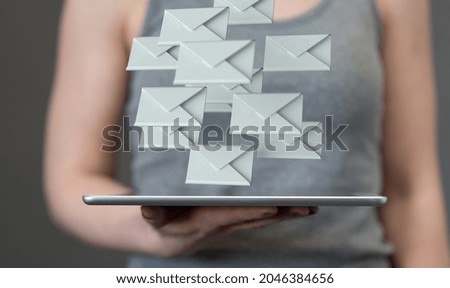 A 3d rendering of white letter concepts over a gray tablet in a woman's hand