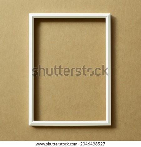 White photo frame on brown background. top view, copy space