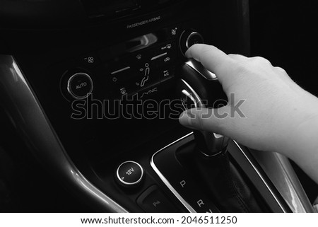 Hand on the gear shift - inside the car. Black and White