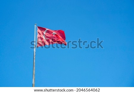 The Flag of Turkey waving in the wind on a background of Blue sky. Horizontal panoramic banner.