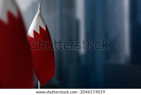 Small flags of Bahrain on a blurry background of the city Royalty-Free Stock Photo #2046574019