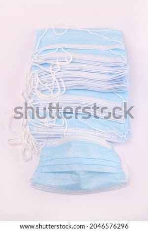 Many piles of blue medical masks on white beach. health concept Royalty-Free Stock Photo #2046576296