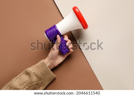 Woman with toy megaphone on color background
