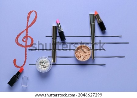 Music notes made of makeup cosmetics on color background