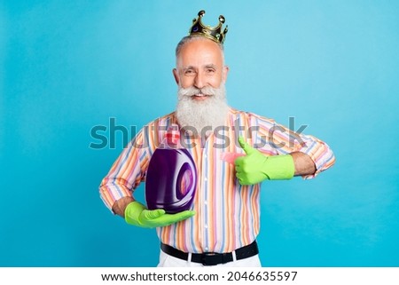 Photo of aged man happy positive smile wear crown show thumb-up like recommend laundry cleaner isolated over blue color background