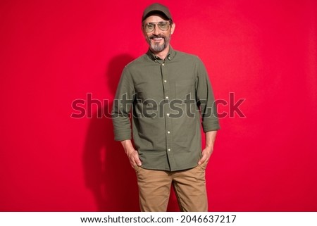 Photo of nice mature brunet man wear khaki shirt eyewear hat isolated on red color background Royalty-Free Stock Photo #2046637217