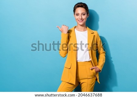 Photo of young attractive girl happy positive smile point thumb empty space ad choose promo isolated over blue color background