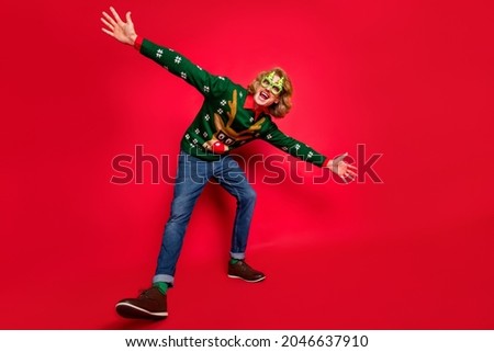 Photo of shiny funny young man wear green sweater spectacles dancing smiling isolated red color background