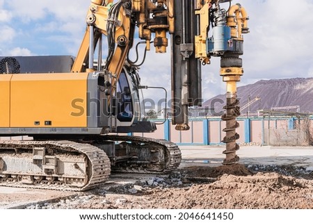 Powerful hydraulic drilling rig on a construction site. Installation of bored piles by drilling. Pile foundations. Drilling in the ground Royalty-Free Stock Photo #2046641450