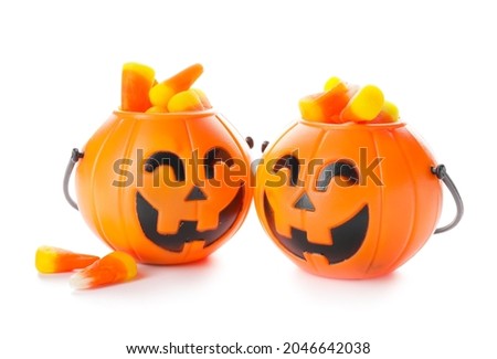 Baskets with tasty scary candies for Halloween on white background