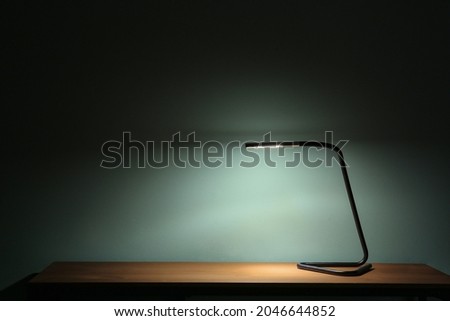 Glowing lamp on table in evening