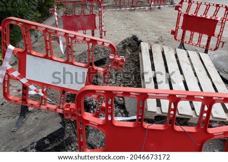 Emergency section of road with a pit fenced with red protective barriers
