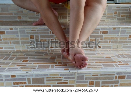 hand woman holding ankle foot numbness muscle inflammation