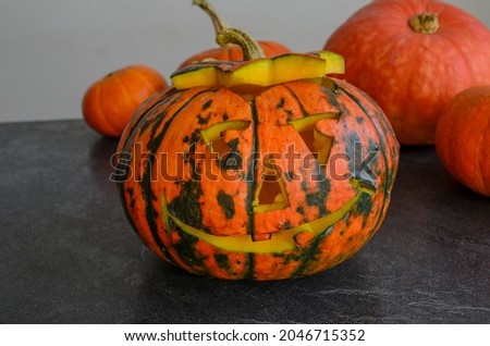 Halloween carved bright orange pumpkin jack lantern with different expressions of immotions on dark textured background