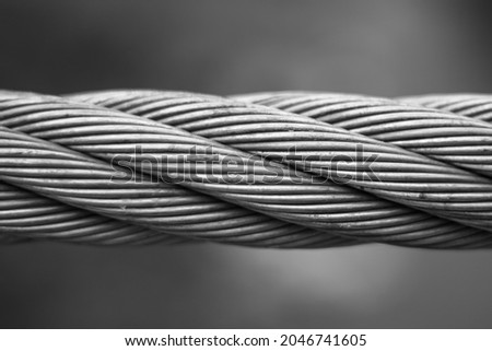 Close up steel cable that connects the suspension bridge on the river Ribnica in black and white.