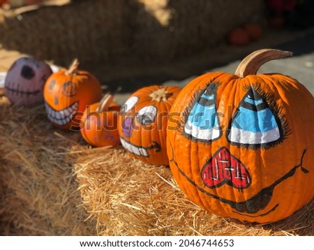 Funny pumpkin faces. Painted pumpkins placed on hay bales at Speer Family Farms Pumpkin Patch.