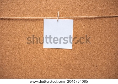 Empty post-it note pinned to corkboard background. Cork board with blank white note for adding text and push pin. Mock up. Empty paper pages for notes copy space for text.