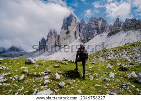 Tre Cime di Lavaredo peaks or Drei Zinnen at sunset, Dobbiaco Toblach, Trentino -Alto Adige or South Tyrol, Italy. Europe Alps. Asian woman hiking in the mountains Royalty-Free Stock Photo #2046756227