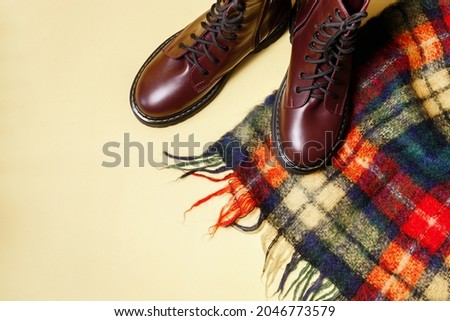 checkered scarf and autumn boots on a yellow autumn background