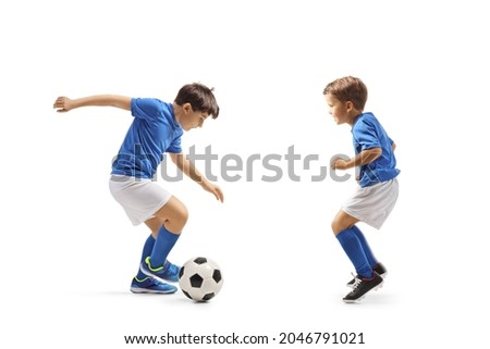 Two boys in football jersey playing with a ball isolated on white background