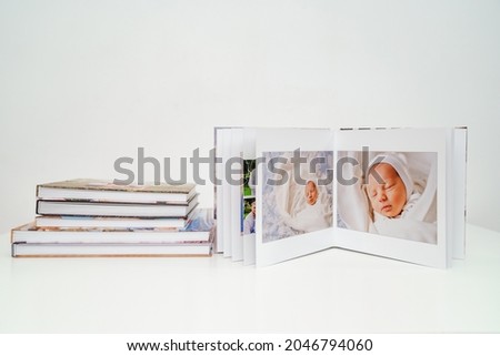 on a white background a photobooks. open photo album from photo shoot with a newborn child. traditions to make a photo album and print photos from important moments of life.