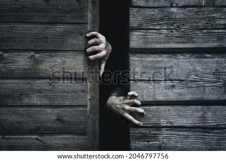 Zombie hands rising out from gap. Old wooden barn. Close up. Darkness horror and halloween background concept.
 Royalty-Free Stock Photo #2046797756