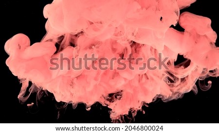 Amazing space magic background. Pink watercolor ink in water on a black background. Pink cloud of ink. Waves and drops of pink paints. Beautiful abstract background.