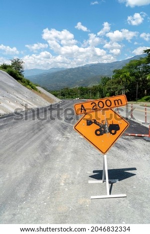 Construction sign over the road and blue sky. Antioquia, Colombia. 