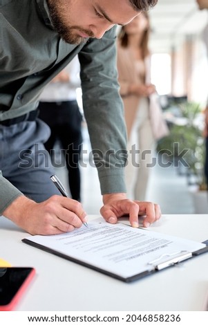 Business man at business meeting after successful negotiations ready to sign agreement official paper close up focus on businesswoman hands holding pen affirm contract with signature. copy space