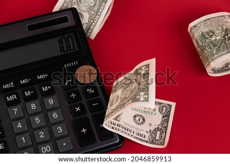 Cash, calculator scattered on a red background. Copy space.