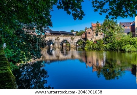 A tree framed view towards the Elvet Bridge in Durham, UK in summertime Royalty-Free Stock Photo #2046901058