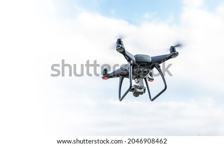 Modern drone in the sky with clouds.