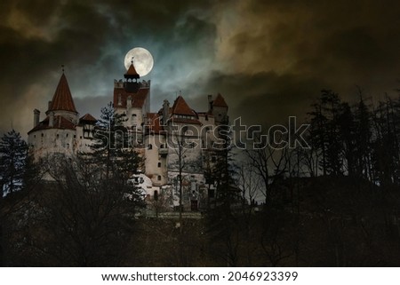 Moon in the clouds over Bran Castle, Transylvania, Romania. Medieval building, Dracula's Castle. Mystical night landscape. Royalty-Free Stock Photo #2046923399