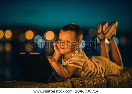 Little boy playing games on his tablet.People,fun,happiness and technology concept.