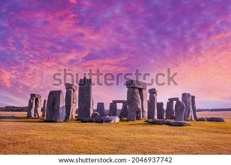 Stonehenge under dramatic sunset sky with long shadows