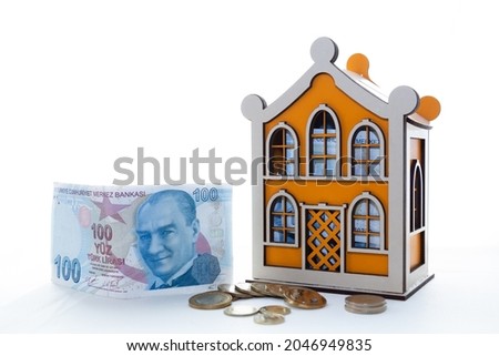 Saving Money concept for Business, Financial and Investment. Wooden house moneybox, banknotes and coins on white backdrop.