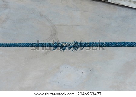 Worn blue rope on a moored ferry.