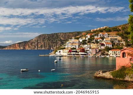 A view at blue bay, sea-front street of Asos village, greek colorful houses and turquoise Ionian Sea water. Luxury summer vacation and holiday at Cephalonia island. Greek island travel background