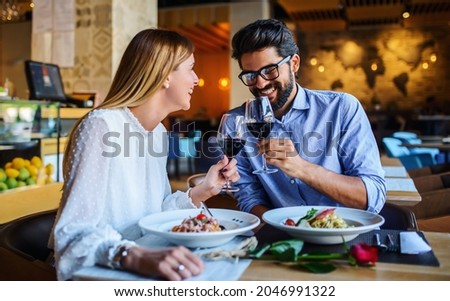 Loving couple enjoying lunch in the restaurant, eating paste and drinking red wine. Lifestyle, love, relationships, food concept Royalty-Free Stock Photo #2046991322