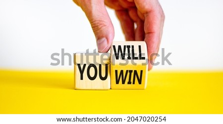 You will win symbol. Businessman turns a cube and changes words you will to you win. Beautiful white and yellow background, copy space. Business, motivational and you will win concept.